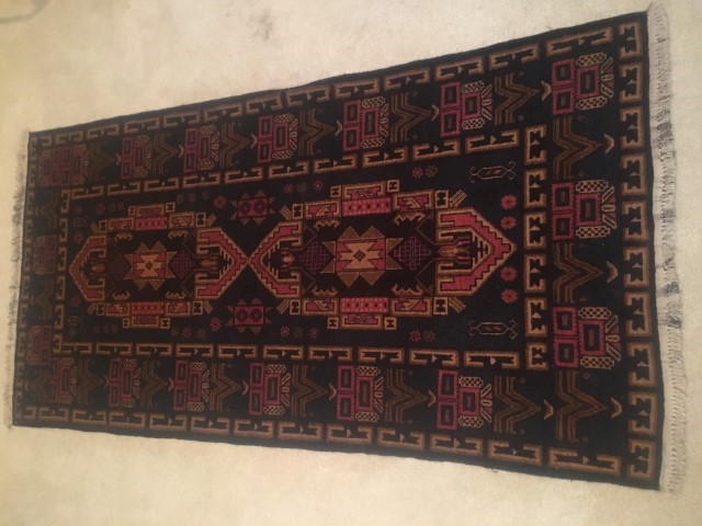 hand knotted tribal rug rust background