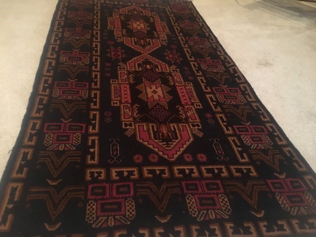 hand knotted tribal rug rust background